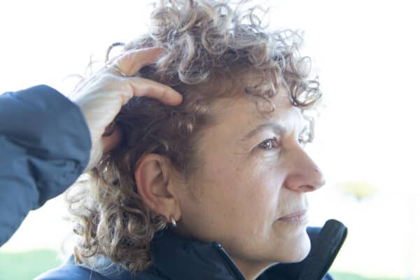 Side view of woman wearing hearing technology.