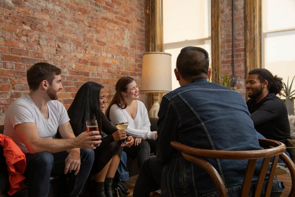 Small group of people sitting and talking wearing hearing aids.