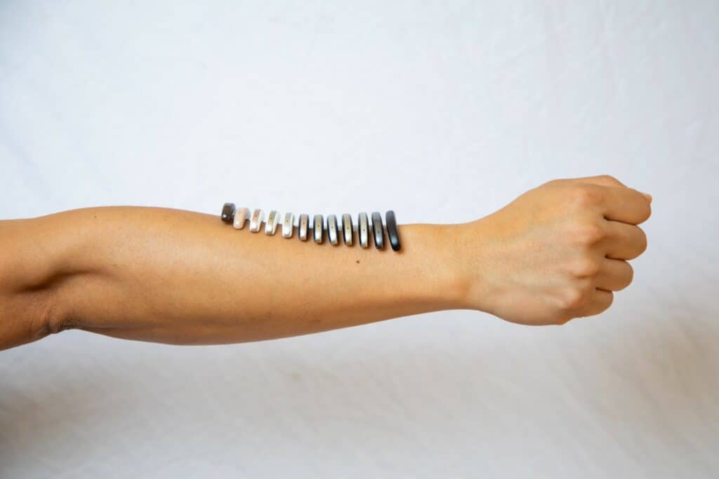 Women with her arm stretched out with a bunch of hearing aids on it.