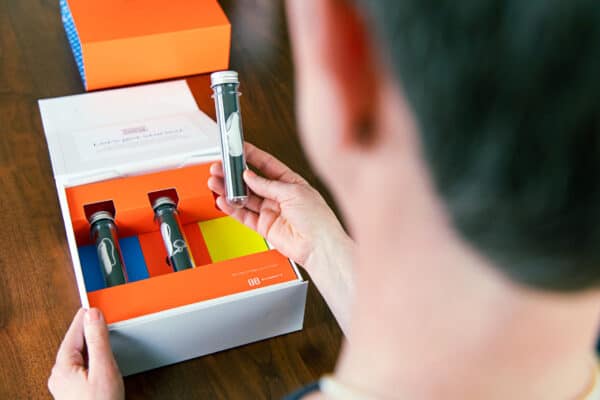 Women holding and looking at hearing aid in packaging.